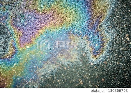 Rainbow oil spill creating an iridescent sheen on wet asphalt Rainbow oil spill creating an iridescent sheen on wet asphalt 130866798