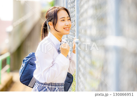 校舎の前に立つ制服を着た女子高生 130866951