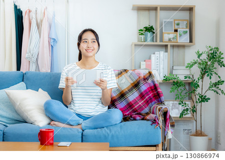 ソファーでくつろぐ若い女性 ソファーでくつろぐ若い女性 130866974
