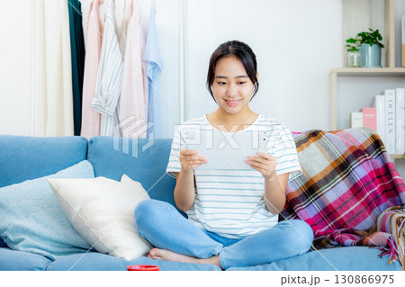 ソファーでくつろぐ若い女性 ソファーでくつろぐ若い女性 130866975