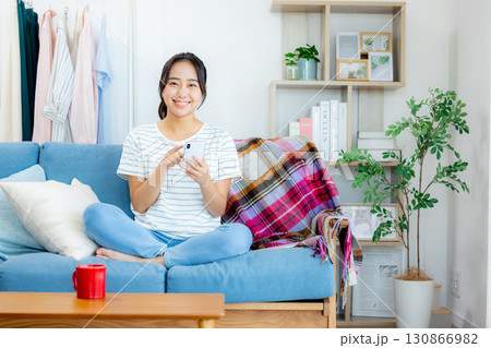 リビングでスマホを見る女性 130866982