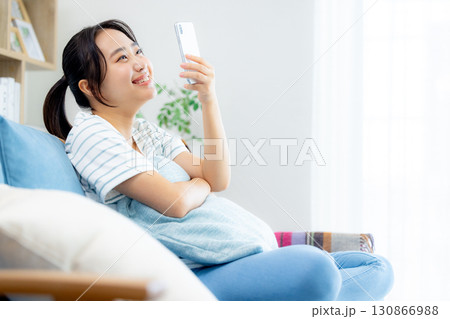 リビングでスマホを見る女性 130866988