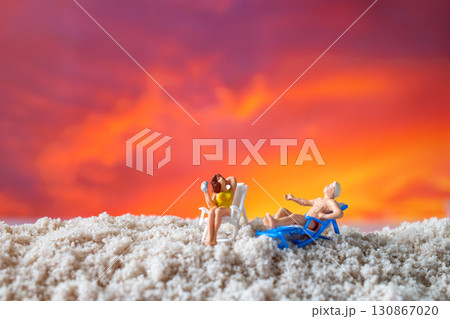 Miniature Couple Relaxing on Beach Chairs at Sunset Miniature Couple Relaxing on Beach Chairs at Sunset 130867020