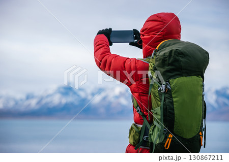 Backpacking woman hiking on high altitude mountain top 130867211