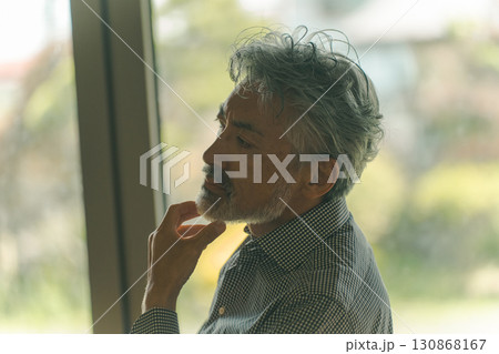 ヒゲを触るシニア男性 130868167