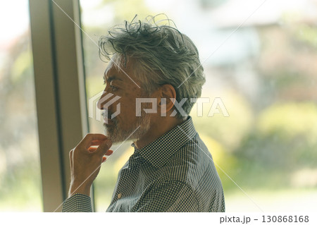 ヒゲを触るシニア男性 130868168