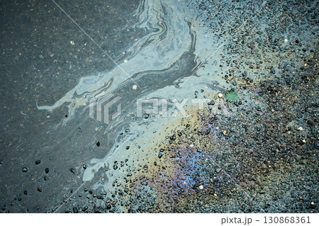 Colorful fuel spill generating intriguing shapes on the damp pavement after the rain. Colorful fuel spill generating intriguing shapes on the damp pavement after the rain. 130868361
