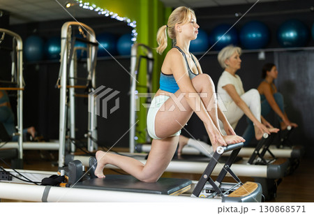Athletic woman doing leg exercises on reformer 130868571
