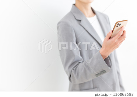 スマホを持つスーツ姿のミドル女性ビジネスウーマン 130868588