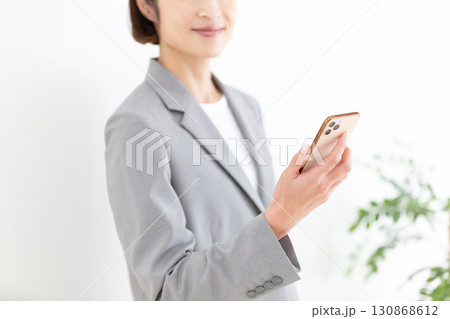 スマホを持つスーツ姿のミドル女性ビジネスウーマン 130868612
