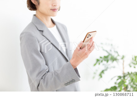 スマホを持つスーツ姿のミドル女性ビジネスウーマン 130868711