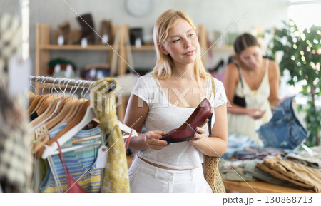 Young woman with her friend choosing high heels in store 130868713