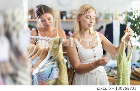 Two young women choosing top in store Two young women choosing top in store 130868733