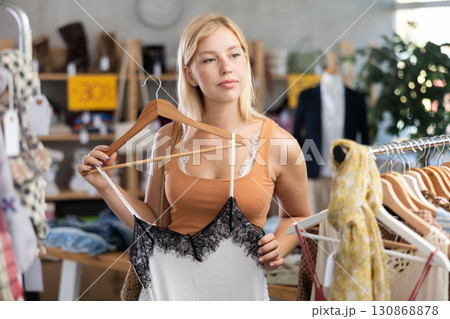 Young woman choosing top in clothing store 130868878