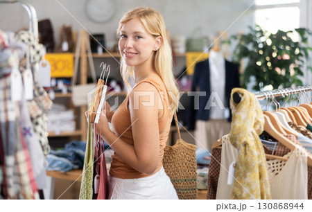 Fashionista girl near showcase examine goods, buying something clothing for summer. 130868944