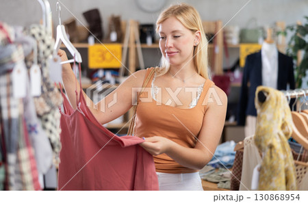 Young woman choosing jumpsuit in clothing store 130868954