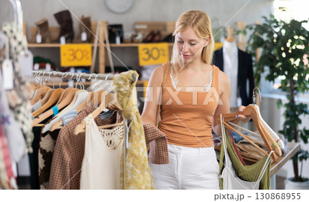 Fashionista girl near showcase examine goods, buying something clothing for summer. 130868955