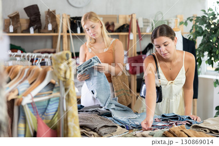 Two women choosing high-quality jeans in the store Two women choosing high-quality jeans in the store 130869014