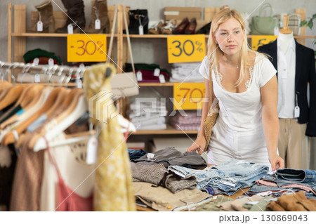 Young woman choosing jeans in clothing store 130869043