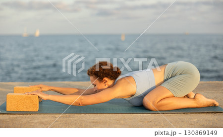 Female yoga instructor performing various asana poses using rectangular blocks Female yoga instructor performing various asana poses using rectangular blocks 130869149