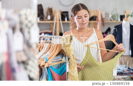 Fashionista girl near showcase examine goods, buying something clothing for summer. 130869156