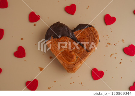 Love concept Valentine's day Heart shaped dark chocolate croissant on beige background with copy space. Puff pastry new trendy sweet dessert bakery. Creamy dough Love concept Valentine's day Heart shaped dark chocolate croissant on beige background with copy space. Puff pastry new trendy sweet dessert bakery. Creamy dough 130869344
