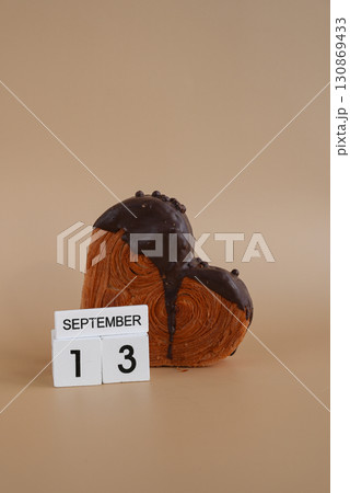 Chocolate day 13 September wooden calendar cubes wishes greeting holiday card Heartshaped pastry croissant treat topped with colorful frosting galore. Food experimentation viral dessert baking trend 130869433