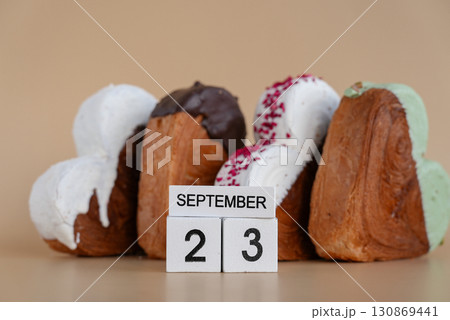 23 September calendar date National Baker day Heart shaped dark chocolate flavor croissant on beige background with copy space. Puff pastry new trendy sweet dessert bakery. Creamy dough 23 September calendar date National Baker day Heart shaped dark chocolate flavor croissant on beige background with copy space. Puff pastry new trendy sweet dessert bakery. Creamy dough 130869441
