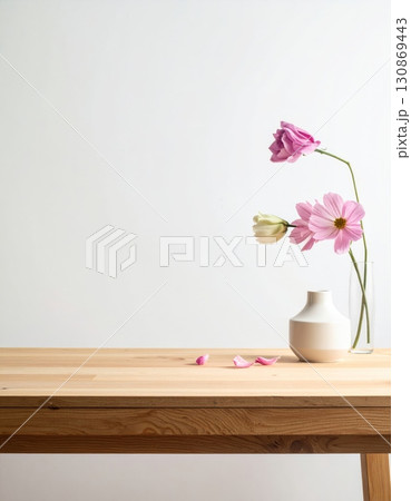 A bouquet of pink flowers in a white glass vase on a wooden table A bouquet of pink flowers in a white glass vase on a wooden table 130869443