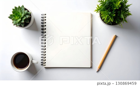 A green leaf and an empty notebook with a pen on a wooden table 130869459