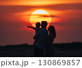 (AI生成)家族イメージ　大きな夕陽と寄り添う親子のシルエット 130869857