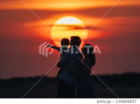 (AI生成)家族イメージ　大きな夕陽と寄り添う親子のシルエット 130869857