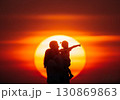 (AI生成)家族イメージ　寄り添う親子の夕陽のシルエット 130869863