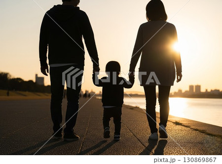 (AI生成)家族イメージ　夕陽を浴びて散歩をする親子のシルエット 130869867