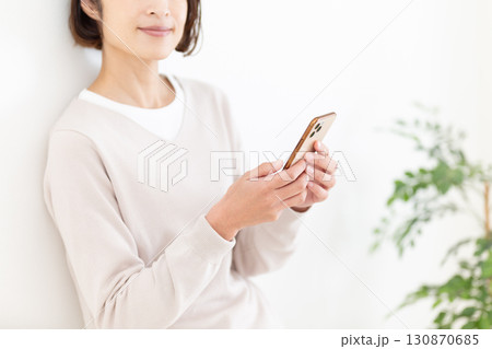 スマホを見るカジュアルのミドル女性ビジネスウーマン スマホを見るカジュアルのミドル女性ビジネスウーマン 130870685
