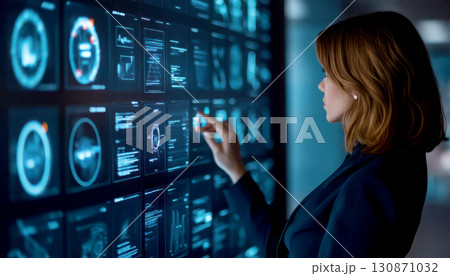 Woman interacting with advanced digital interface screen. 130871032