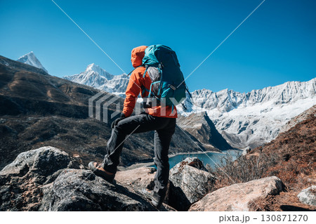 Backpacking woman hiking on high altitude mountain top 130871270