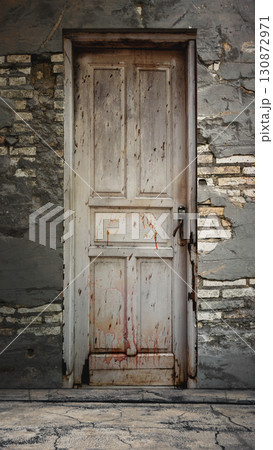 Outdoor view of a weathered and old wooden door with peeling paint on a brick wall background. Mockup or Copy space. Halloween wallpaper or background 130872971