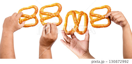 Collection set of human hands holding a salty baked brown pretzel isolated over a white background. Oktoberfest festival Collection set of human hands holding a salty baked brown pretzel isolated over a white background. Oktoberfest festival 130872992