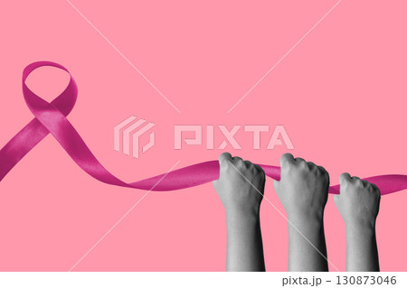Human hand holding a pink ribbon on a colored background. Collage art of Breast Cancer Awareness 130873046