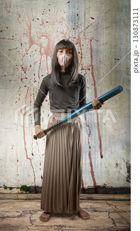 Indonesian southeast asian transgender man dressed as a woman wearing a bloody face mask and holding a baseball bat with splatters of blood background. Concept of Halloween, Sister Hong, or red uncle Indonesian southeast asian transgender man dressed as a woman wearing a bloody face mask and holding a baseball bat with splatters of blood background. Concept of Halloween, Sister Hong, or red uncle 130873111