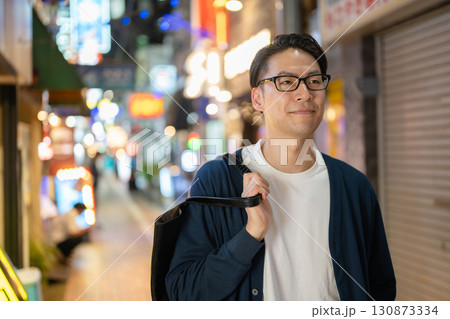 夜の街を歩く男性 130873334