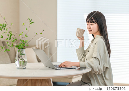 コーヒーを飲んで休憩するリモートワーク,テレワーク,在宅勤務するアジア人女性 コーヒーを飲んで休憩するリモートワーク,テレワーク,在宅勤務するアジア人女性 130873501
