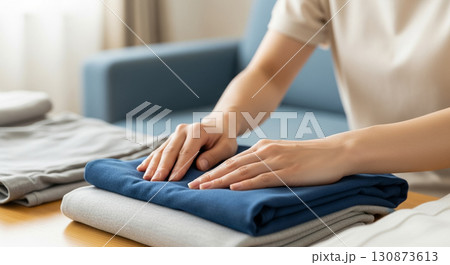 衣服をたたむ若い女性　遺品整理業者 130873613