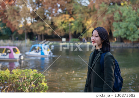 秋の公園で紅葉を眺める笑顔の女性 秋の公園で紅葉を眺める笑顔の女性 130873682
