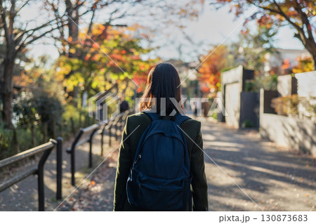 紅葉の街を歩く女性の後ろ姿 130873683