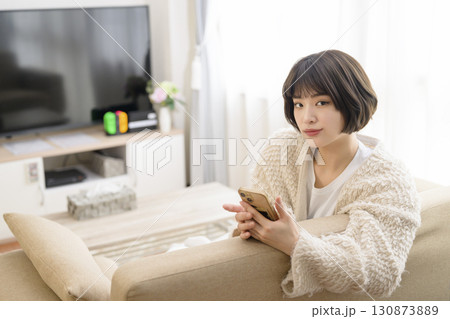 リビングでスマホを見る若い女性 リビングでスマホを見る若い女性 130873889
