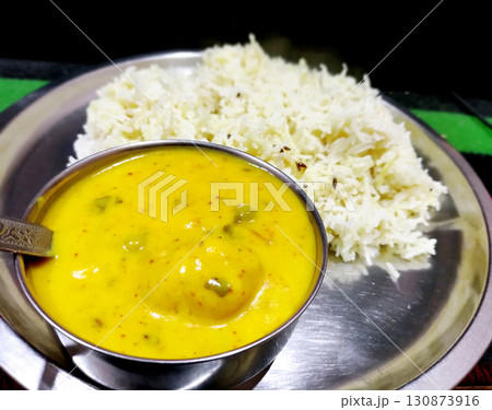 Traditional Indian Kadhi with Steamed Rice Served in Steel Plate 130873916