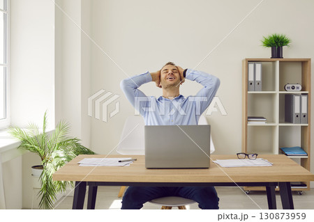 Businessman or corporate employee feels happy and satisfied with successfully completed work 130873959