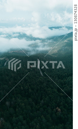 Aerial view over Divcibare, Serbia, showing vast forested hills, valleys, and dramatic clouds above the landscape 130874328